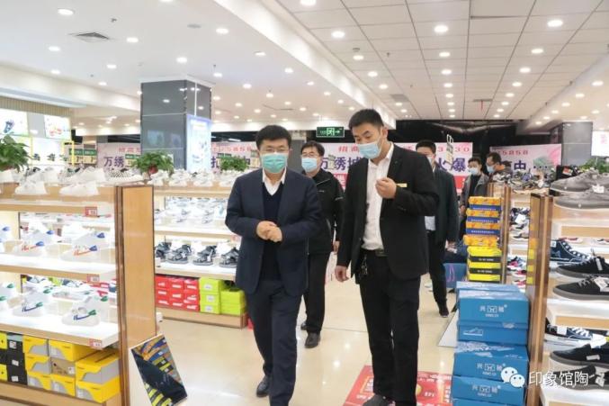 在万绣城服装超市,王立伟认真查看超市出入口体温检测,扫码,人员登记