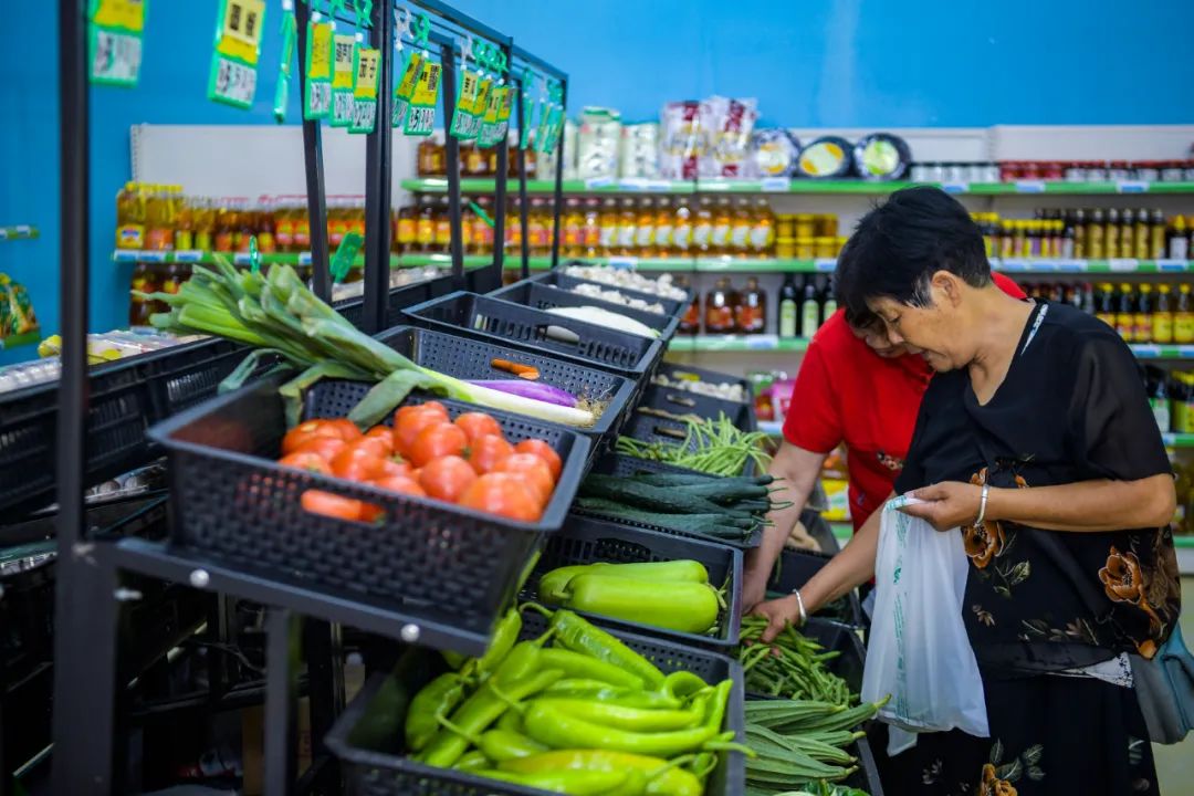 海口市菜篮子平价超市永秀花园店,市民使用全生物降解购物袋装蔬菜.