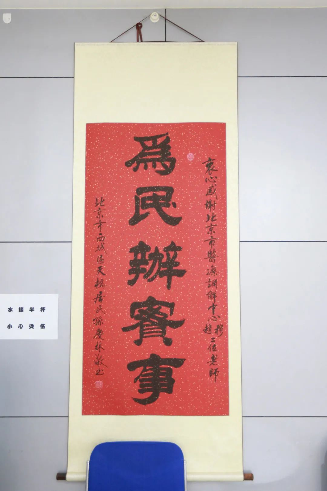 组长对工作站墙上一当事人用毛笔书写的"为民办实事"书法作品印象深刻