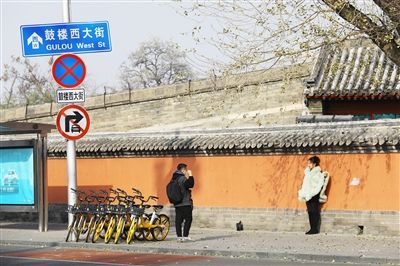 在北京市鼓楼西大街路牌下拍照的游客 中华文化博大精深,源远流长.