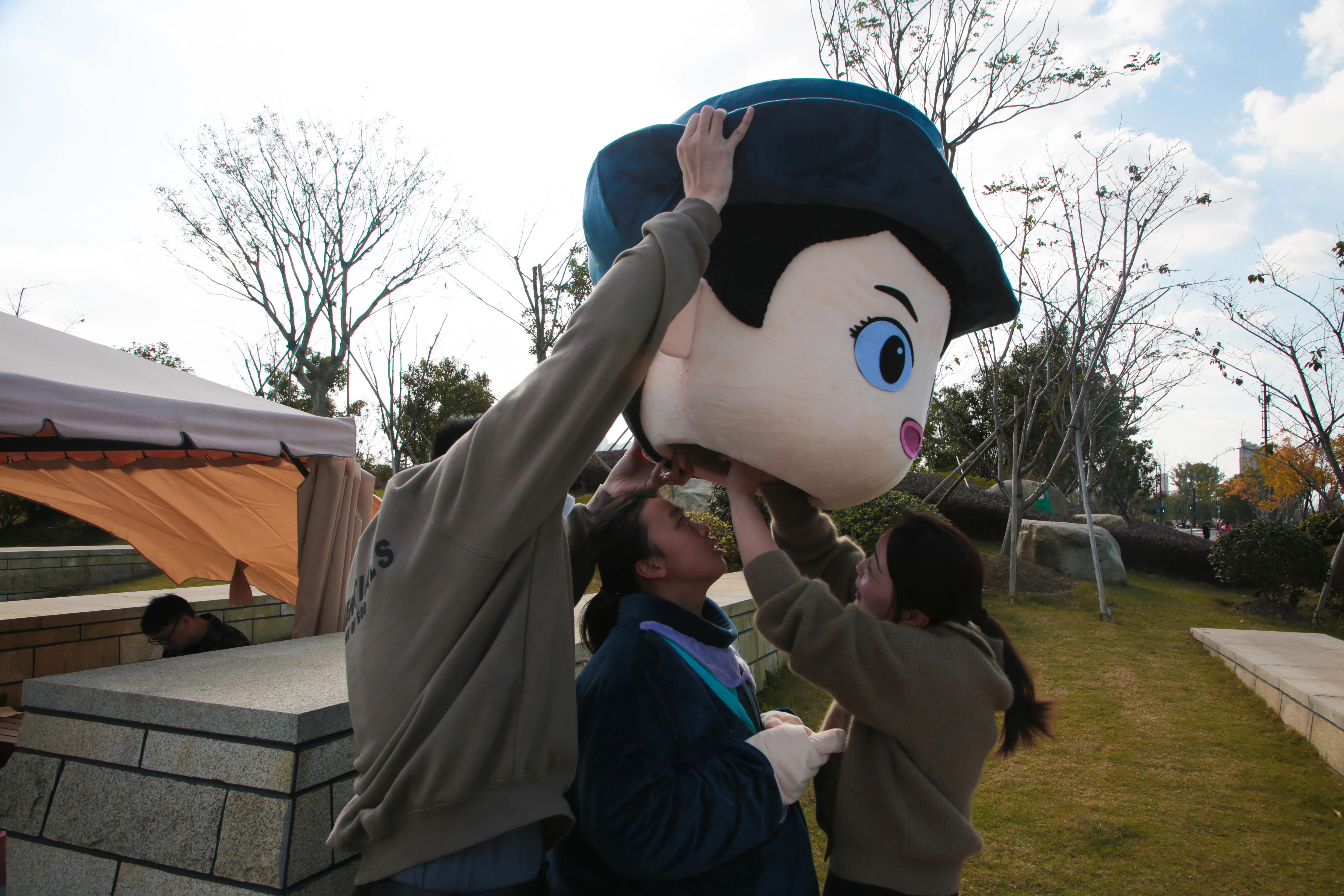 民警与平安志愿者穿上警察人偶服装人偶在公园与在附近游玩的父母和小