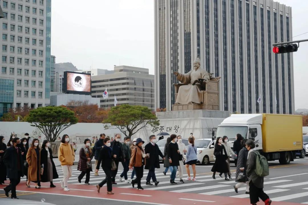 11月15日,行人佩戴口罩在韩国首尔光化门广场过马路.