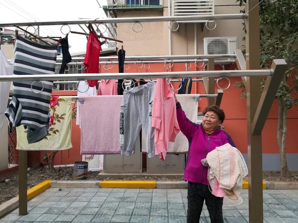 拎着满满一兜刚洗干净的衣服,来到小区晾晒点
