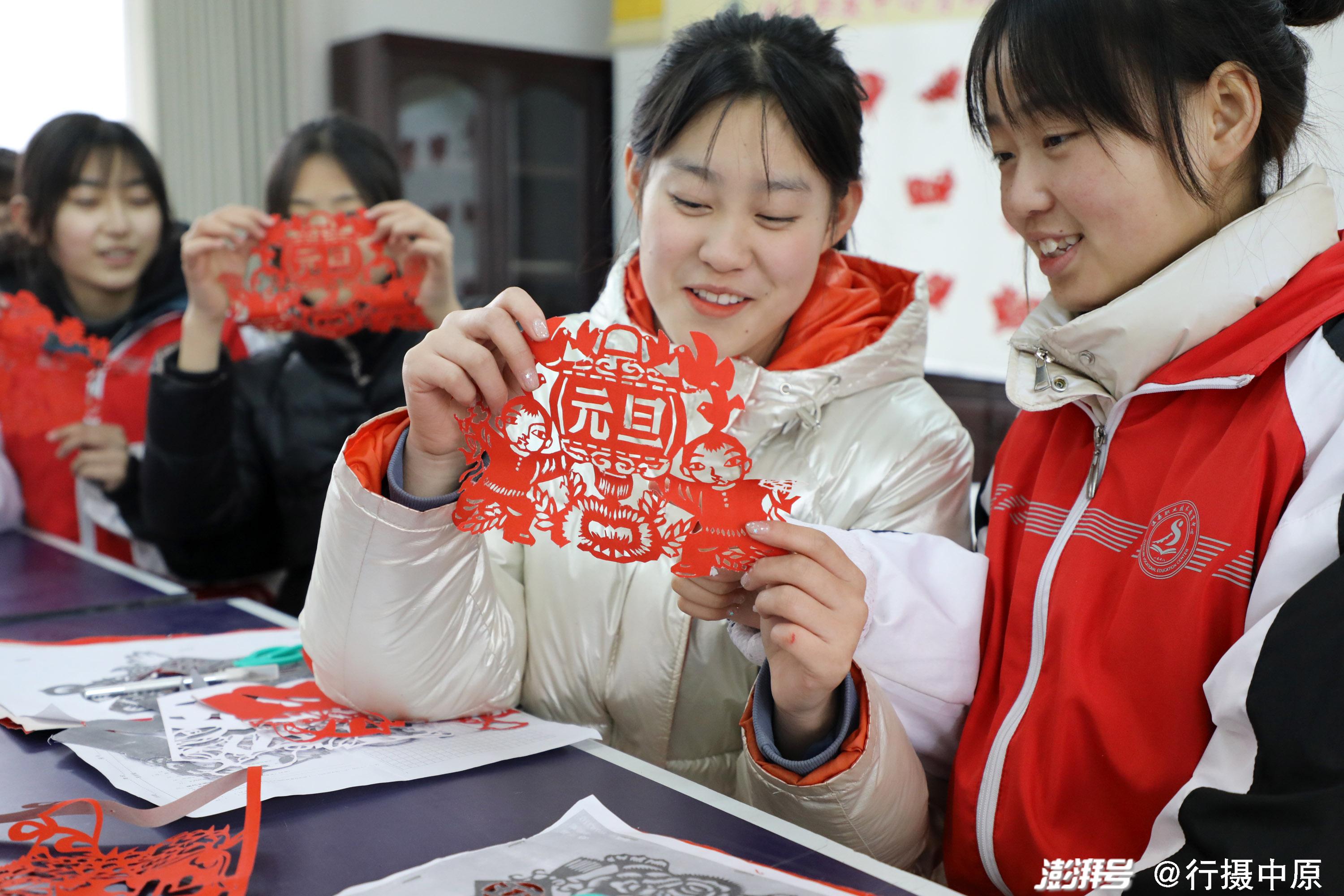 2021年12月31日,河南省焦作市温县职教中心剪纸社团的学生在交流剪纸