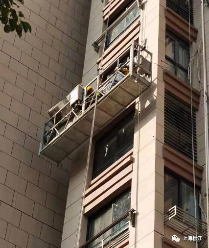 在居民李女士家窗外,两名施工师傅正乘坐在吊篮上,根据此前空调外机