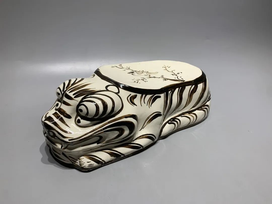 枕面上绘有小鸟图案嘴巴紧闭,尾巴斜托于后侧后腿着地,前脚交迭,高鼻