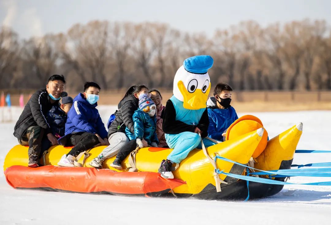 游客在冰雪运动体验区畅玩雪地香蕉船.原标题:《尽享冰雪游园乐》