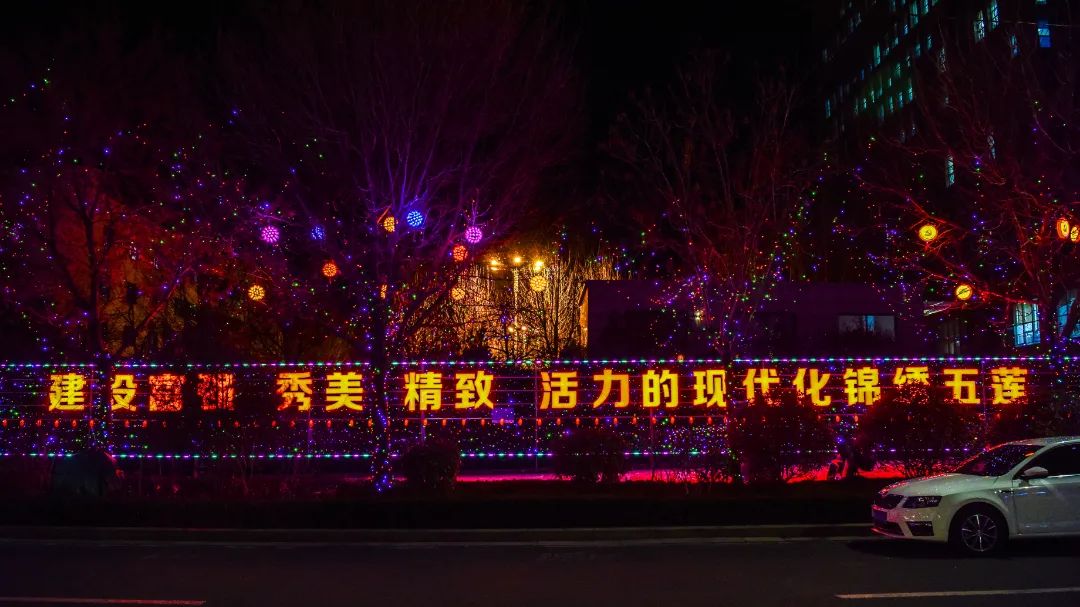 拥抱高铁时代,全面开启建设现代化锦绣五莲新征程"的发光字标语格外引
