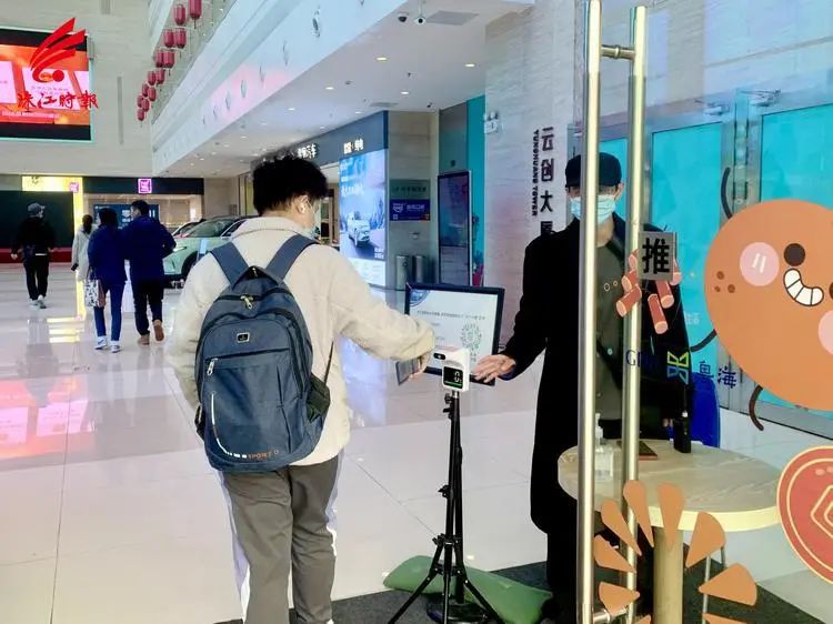 市民在商场入口处进行测温.