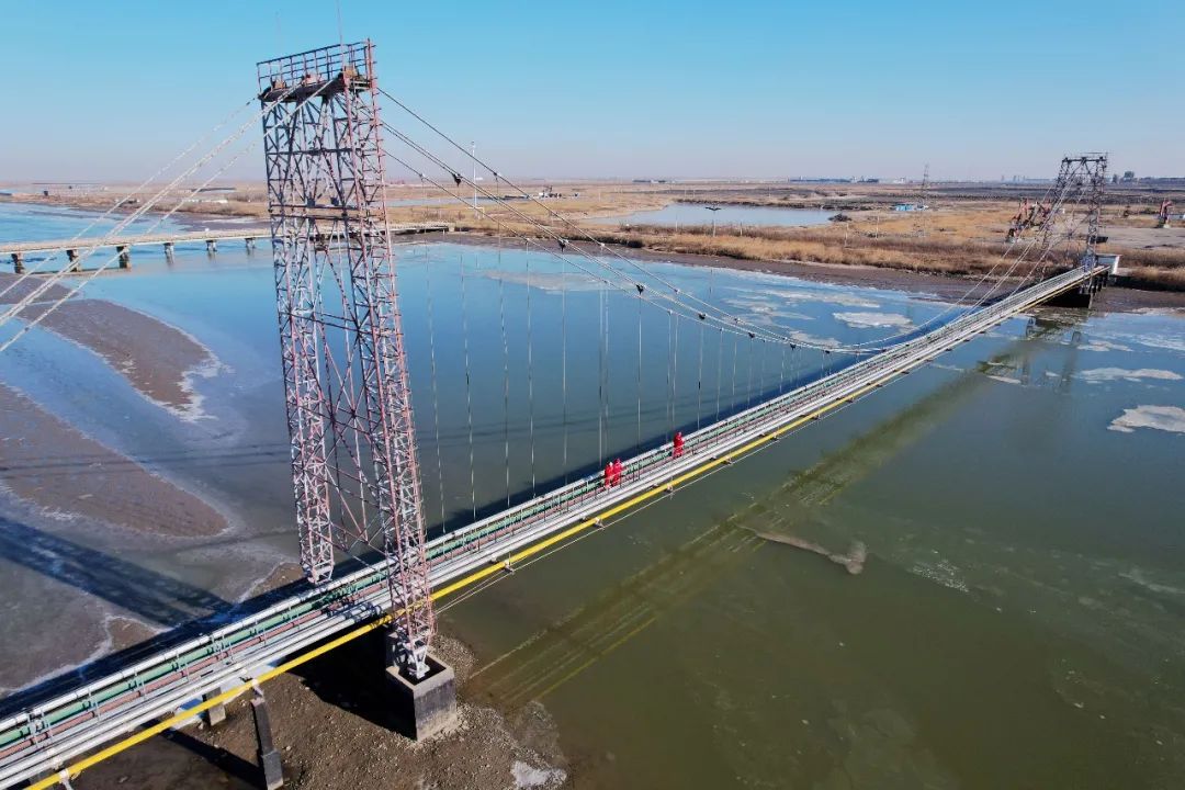 2月17日,在冀东油田高尚堡油区的青龙河跨越管桥上,员工冒着严寒开展