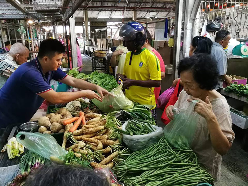 传统巴刹(菜市场)中的商贩与顾客交易(图:光华日报)