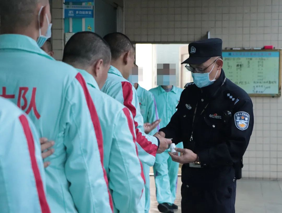 强制隔离戒毒所执勤民警正在仔细地给患病需要服药的戒毒人员分发药品