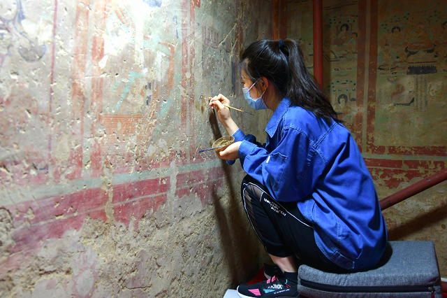 壁画修复师正在修复壁画近年来,敦煌研究院在做好莫高窟等甘肃省内