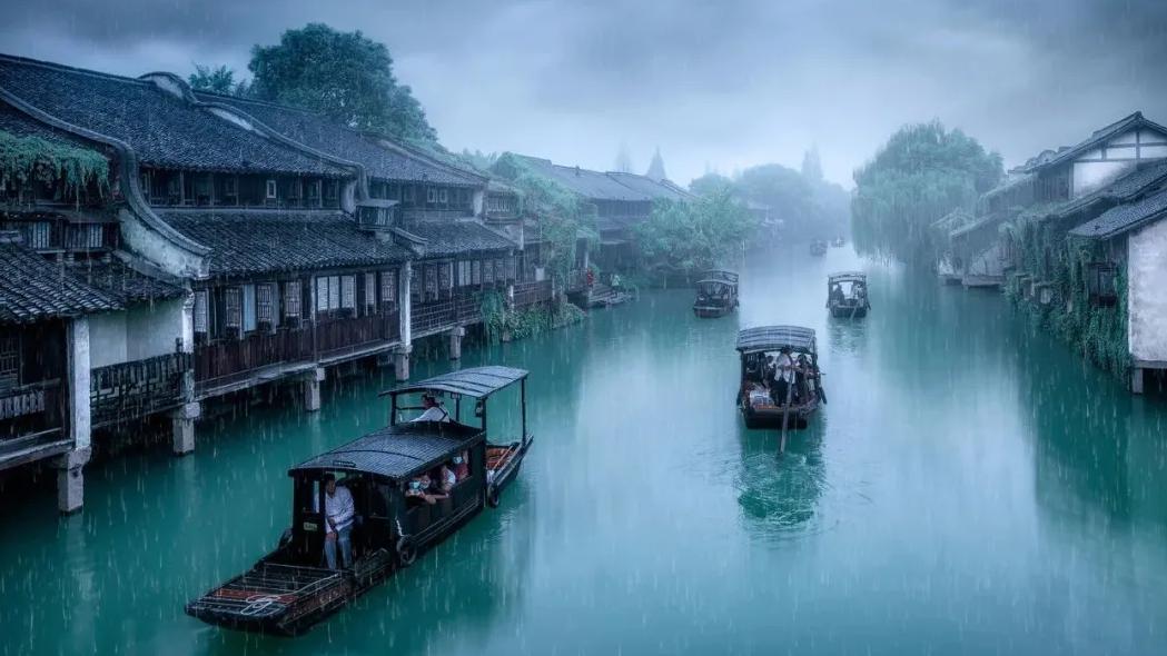 片薄雾般淡青色的烟雨里,烟雨的尽头是一汪迷离得精致的天空,游弋着数