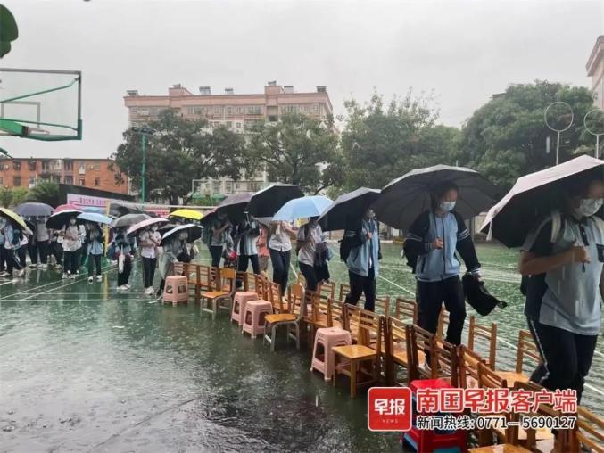 雨中这一幕令人动容!南宁一学校老师赤脚蹚水,为学生搭凳子桥