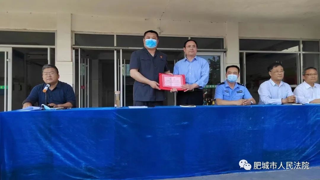 在石横中学校长谭胜伟为石横法庭刁剑法官颁发法治副校长聘书后,刁剑