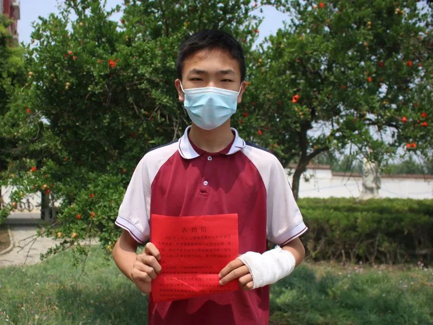 "望都第四中学九年级37班学生李易璋手持学校颁发的奖状激动地说道.