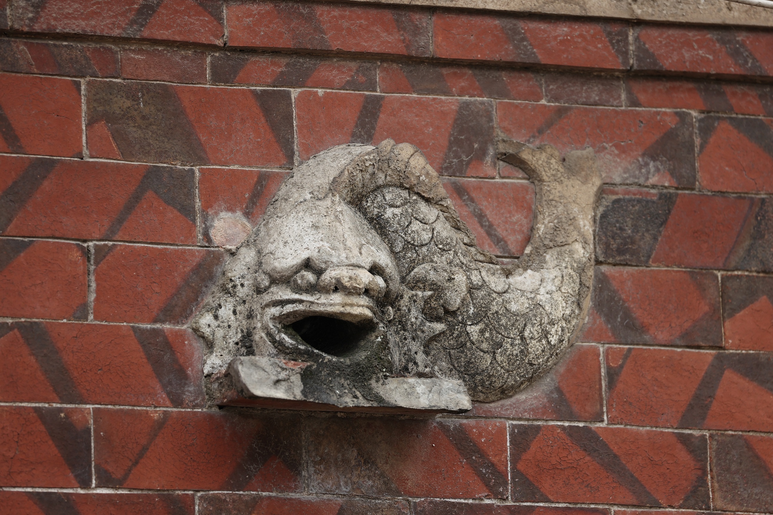 闽南红砖墙上的狮头鱼身石灰塑像(陈英杰摄)