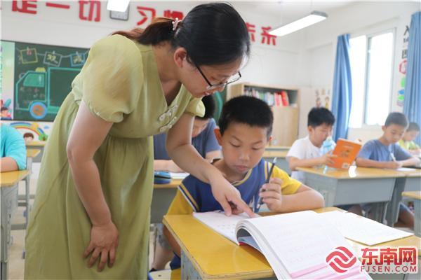 三明市实验小学语文老师吴宝琴在辅导学生做作业 东南网记者 蔡晓卿