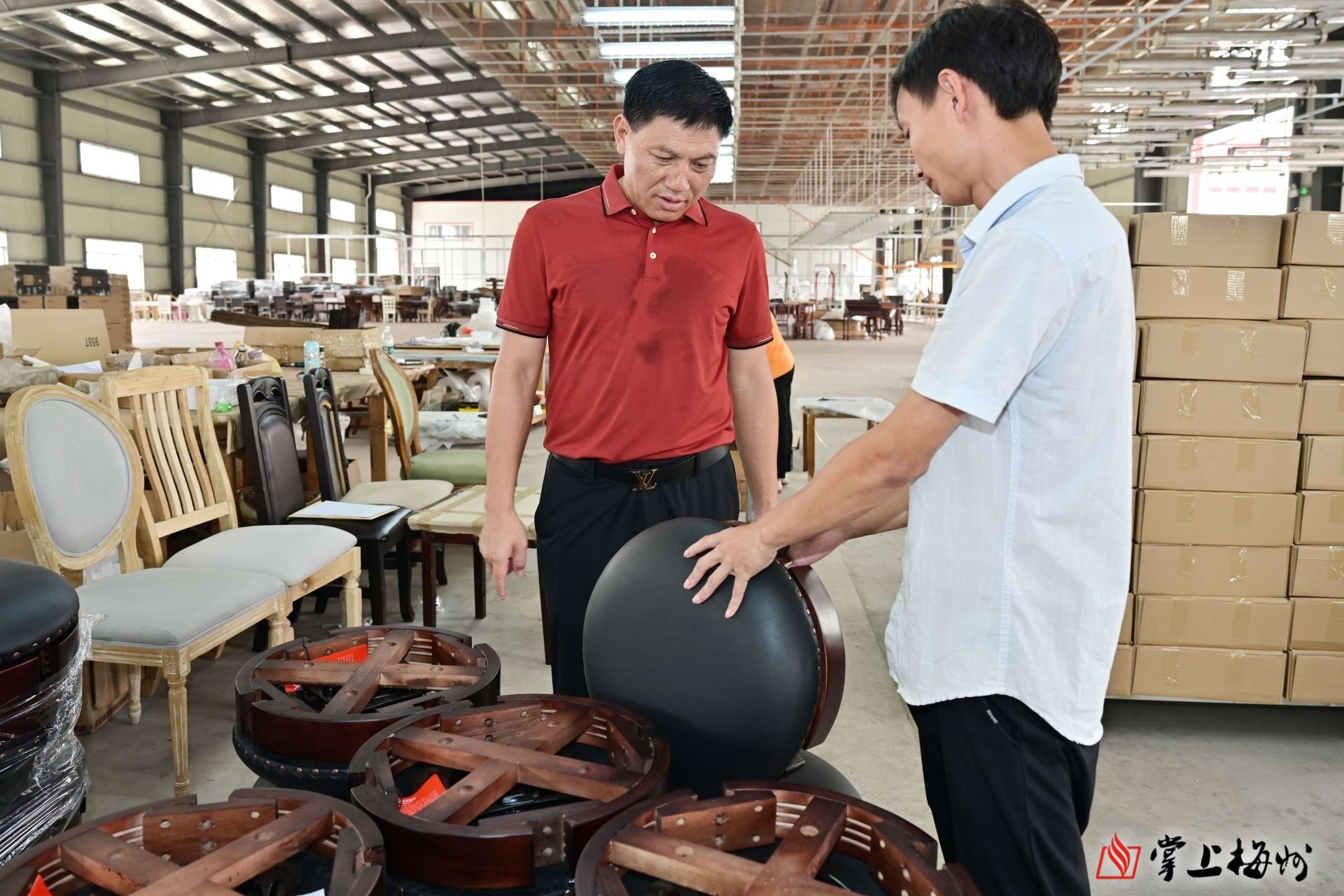 杨洪良（左）查看家具生产情况。