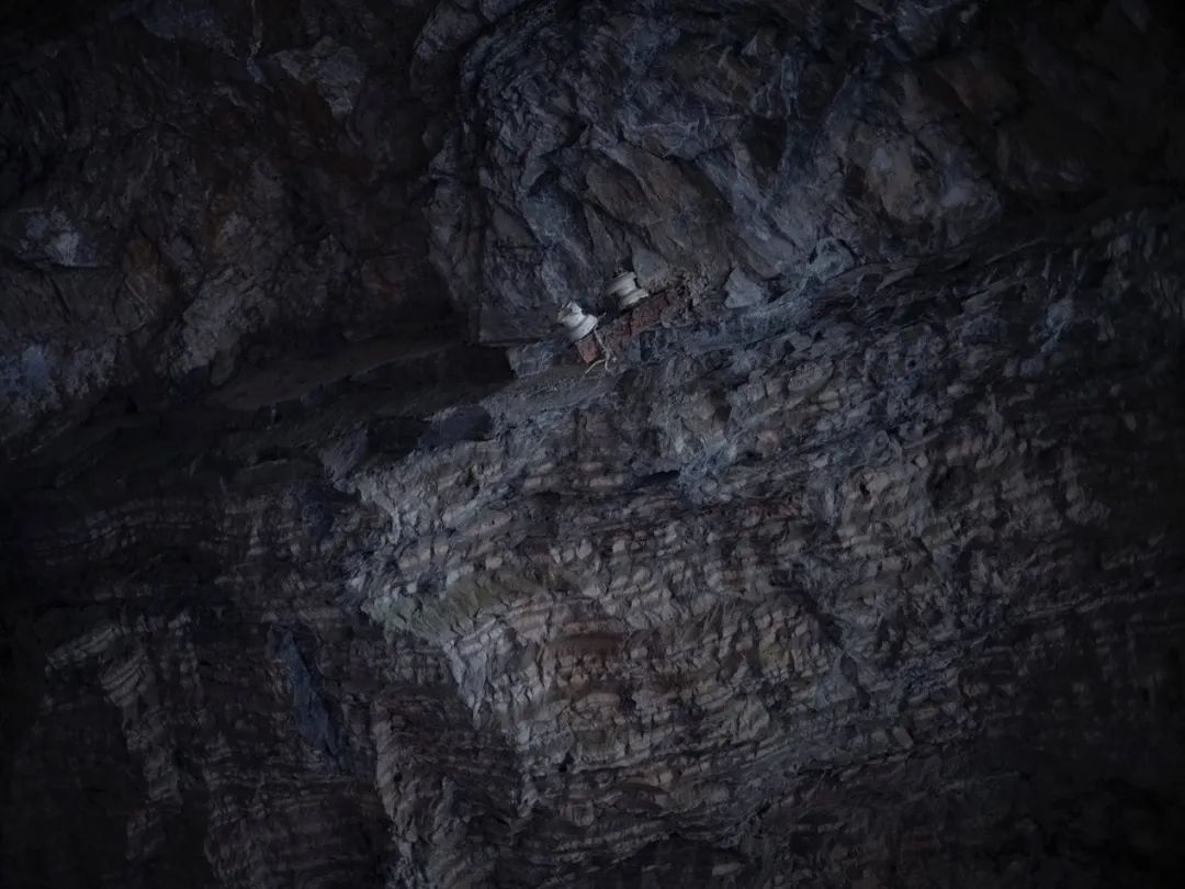 ●汞矿隧道中没有灯光，层层岩壁上依然留着工人(ren)在此工作的(de)痕迹。