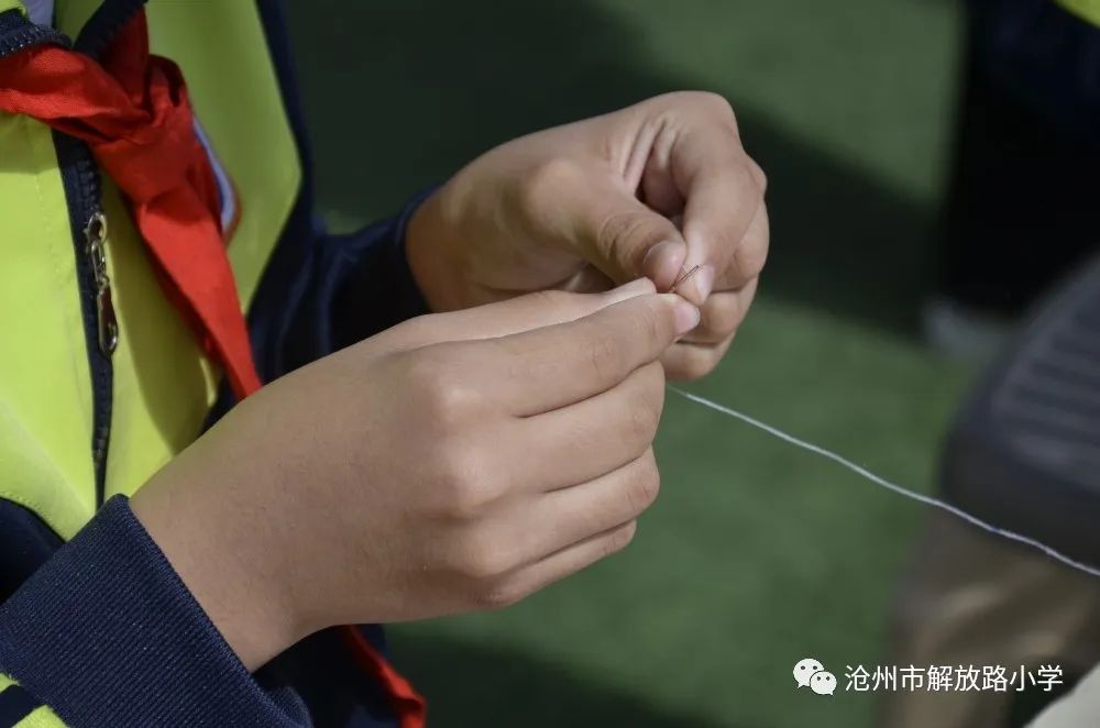 三年级钉纽扣二年级同学较量的是系鞋带.