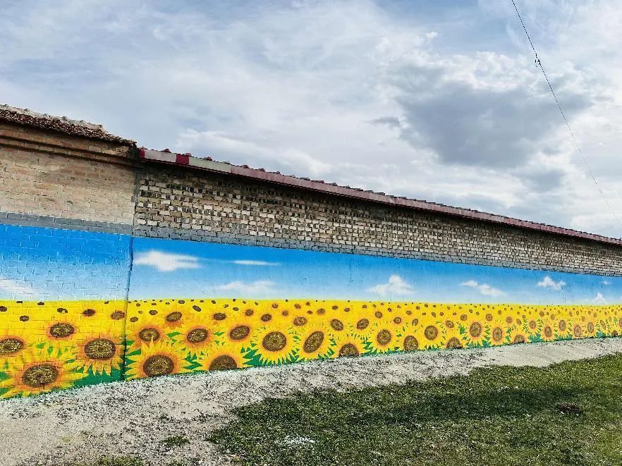 墙画既有草原蓝天,向日葵花海,又有勤劳的农民和丰收的景象,还有栩栩