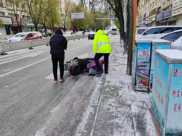 交警在长春花园路口执勤时,看到一行人骑电动自行车因雪天路滑摔倒,忙