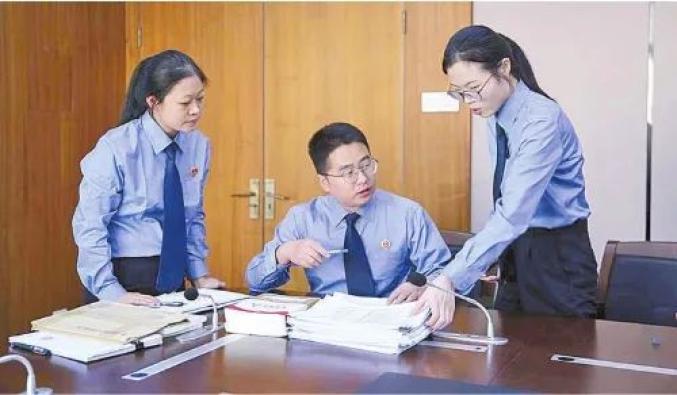▲办案检察官在研究案情接到申请后，检察官查阅了卷宗并向金融机构调取