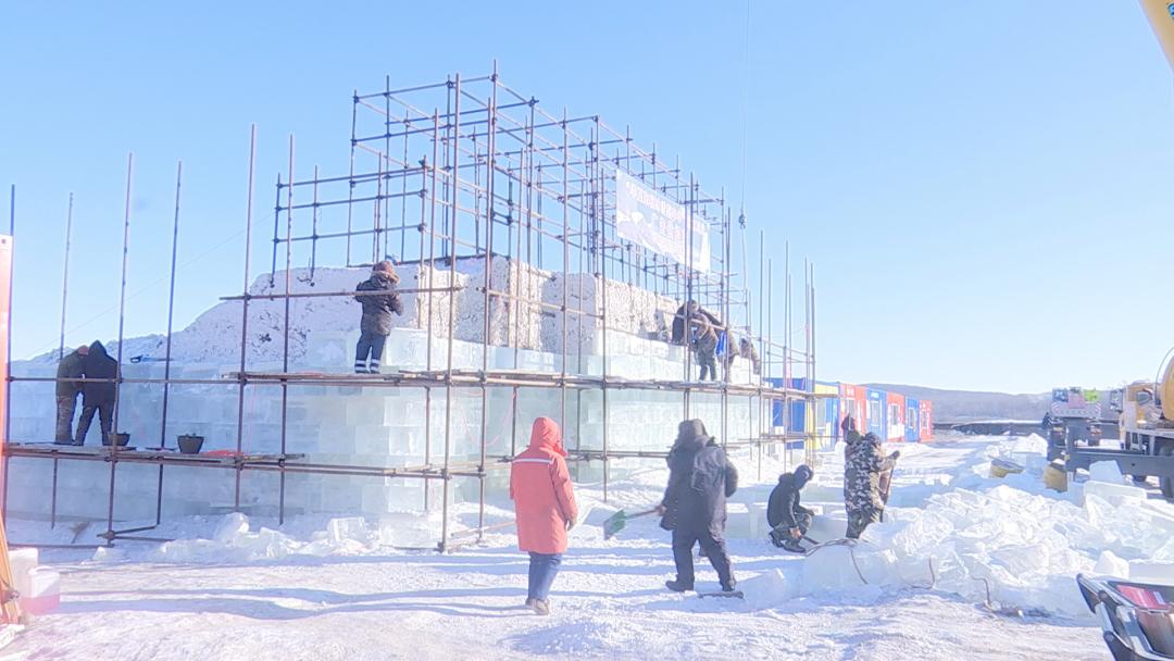 在冰雪世界的施工现场,工人们正在用冰块为大滑梯张贴"外衣",长达200