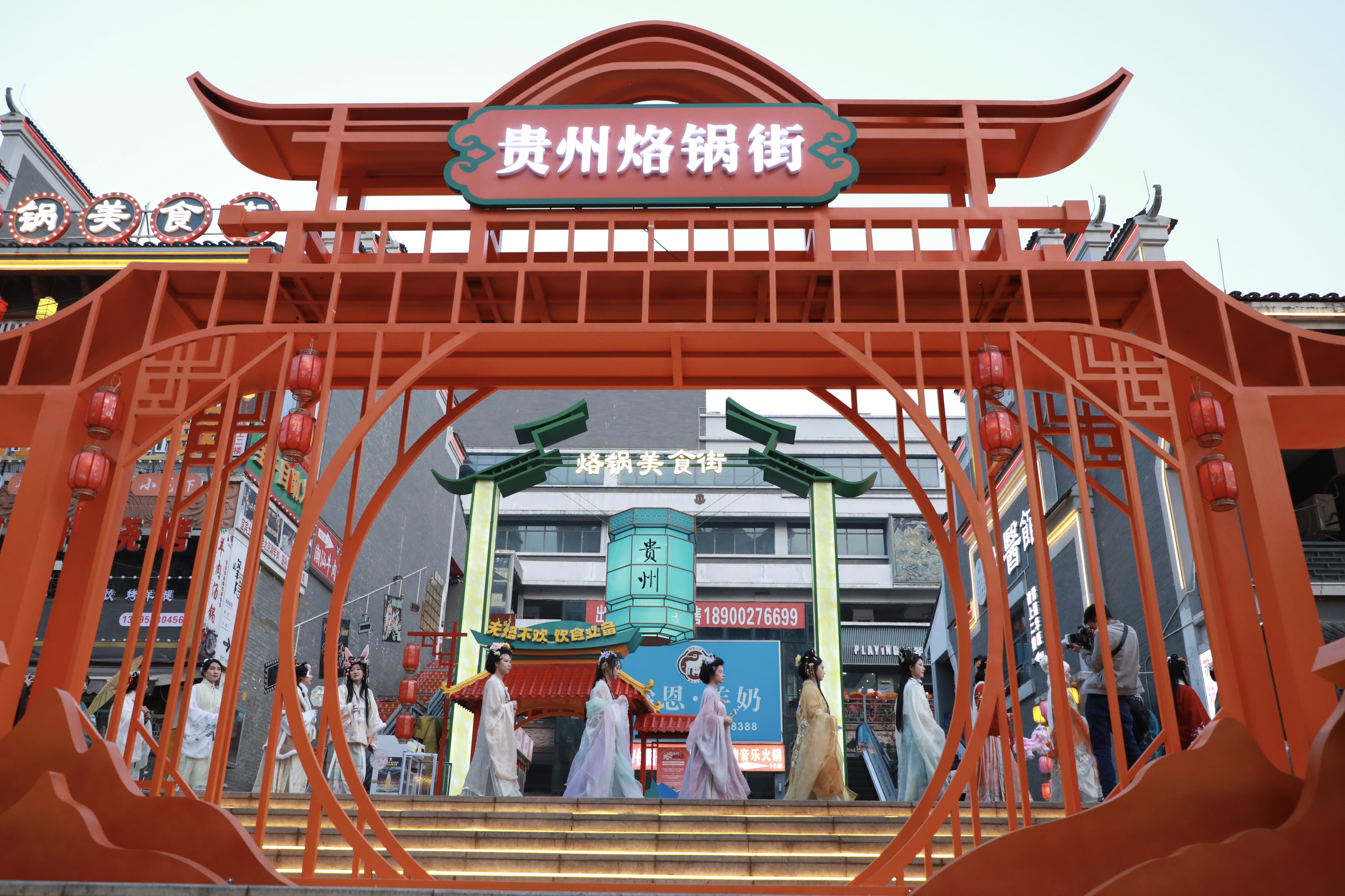 身穿汉服的小姐姐向过往市民发放小礼品据悉,继烙锅美食街开街仪式后