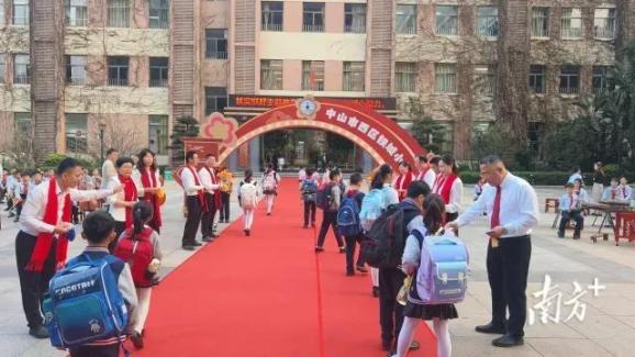 西区铁城小学舞狮贺岁,同学们走过红地毯,满心欢喜地在福气墙贴上"福"