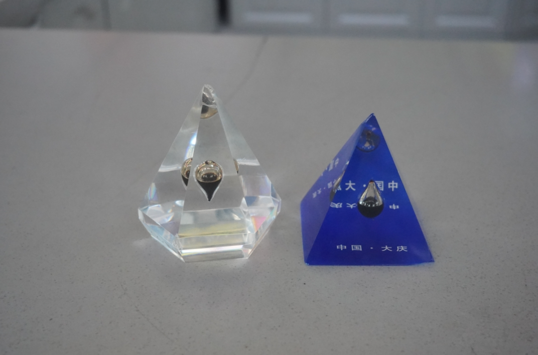 王自先生特地带回了2个具有大庆特色的"一滴油"纪念品,如获珍宝一样