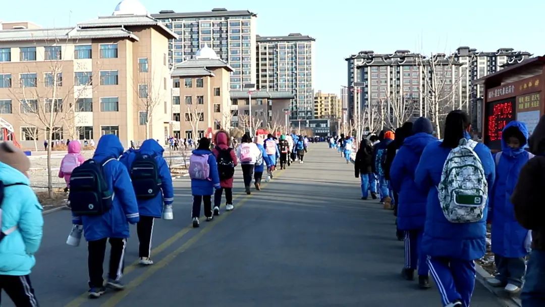 只见突泉县工农小学的老师们正在学校门口微笑着迎接学生们的到来