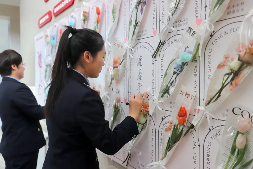 在突泉县税务局活动现场,布置了创意十足的鲜花签到墙,女职工们纷纷