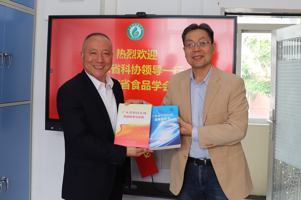 期间,广东省科协党组成员华旭初向学会理事长赠送书籍.