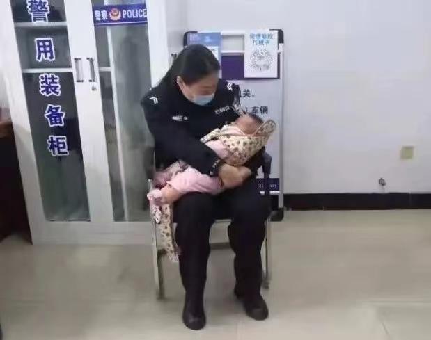法庭的走廊里,身穿制服的女法警抱着一名婴儿,轻轻安抚着,婴儿在法警