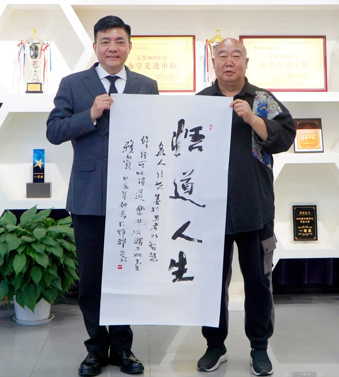 著名作家,书法家,四川作家书画院院长牛放(右)向学校赠送书法作品采风