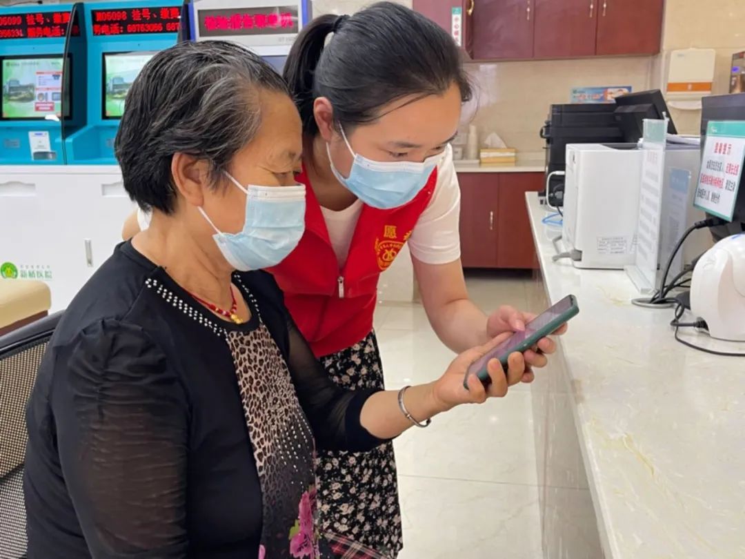 新桥医院新时代文明实践点志愿者帮助老人预约挂号,查询报告等.