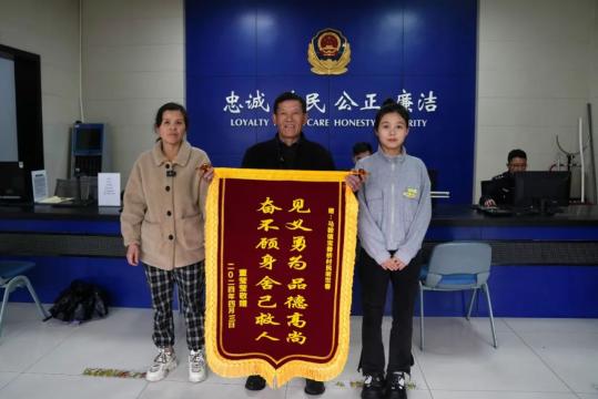 被救的00后女孩董莹莹和母亲也赶来现场,将一面印有"见义勇为品德高尚