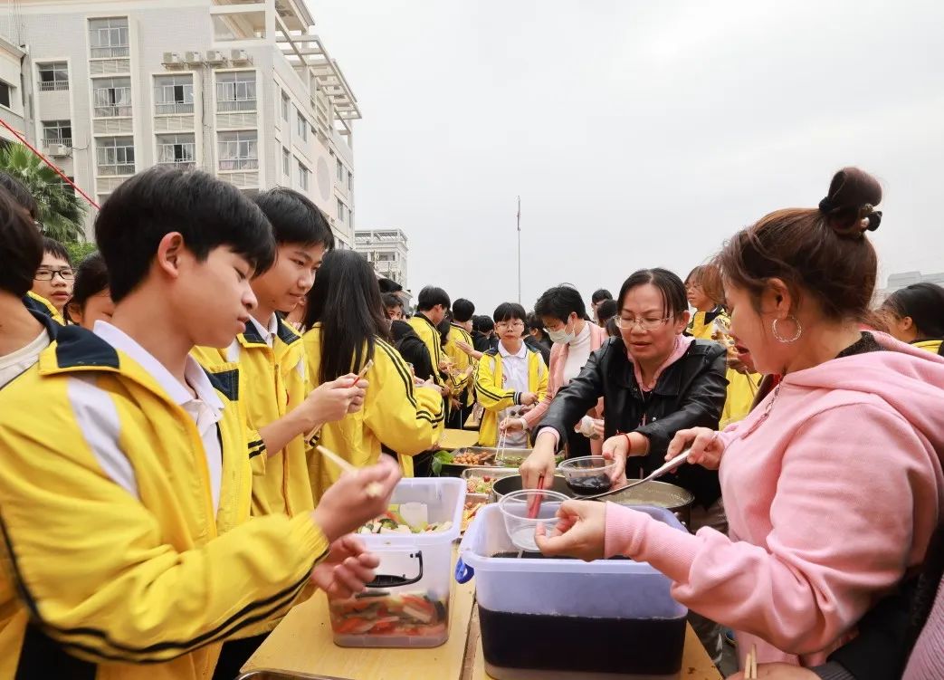 "县民族初级中学教师臧秋平在与同学们享受美食中也不忘普及五色糯米