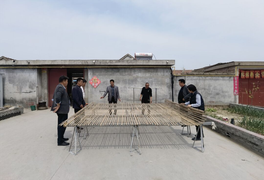 近日,记者来到八义集镇石横村,村干部正在向村民展示新型大蒜晾晒架.
