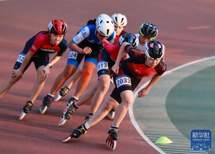 四川省速度轮滑队选手李沛谕(右一)在女子甲组10000米淘汰赛比赛中