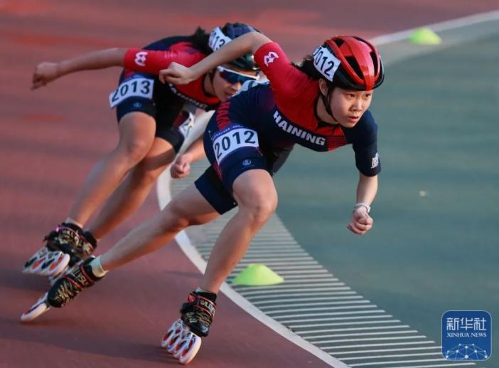 四川省速度轮滑队选手李沛谕(右一)在女子甲组10000米淘汰赛比赛中