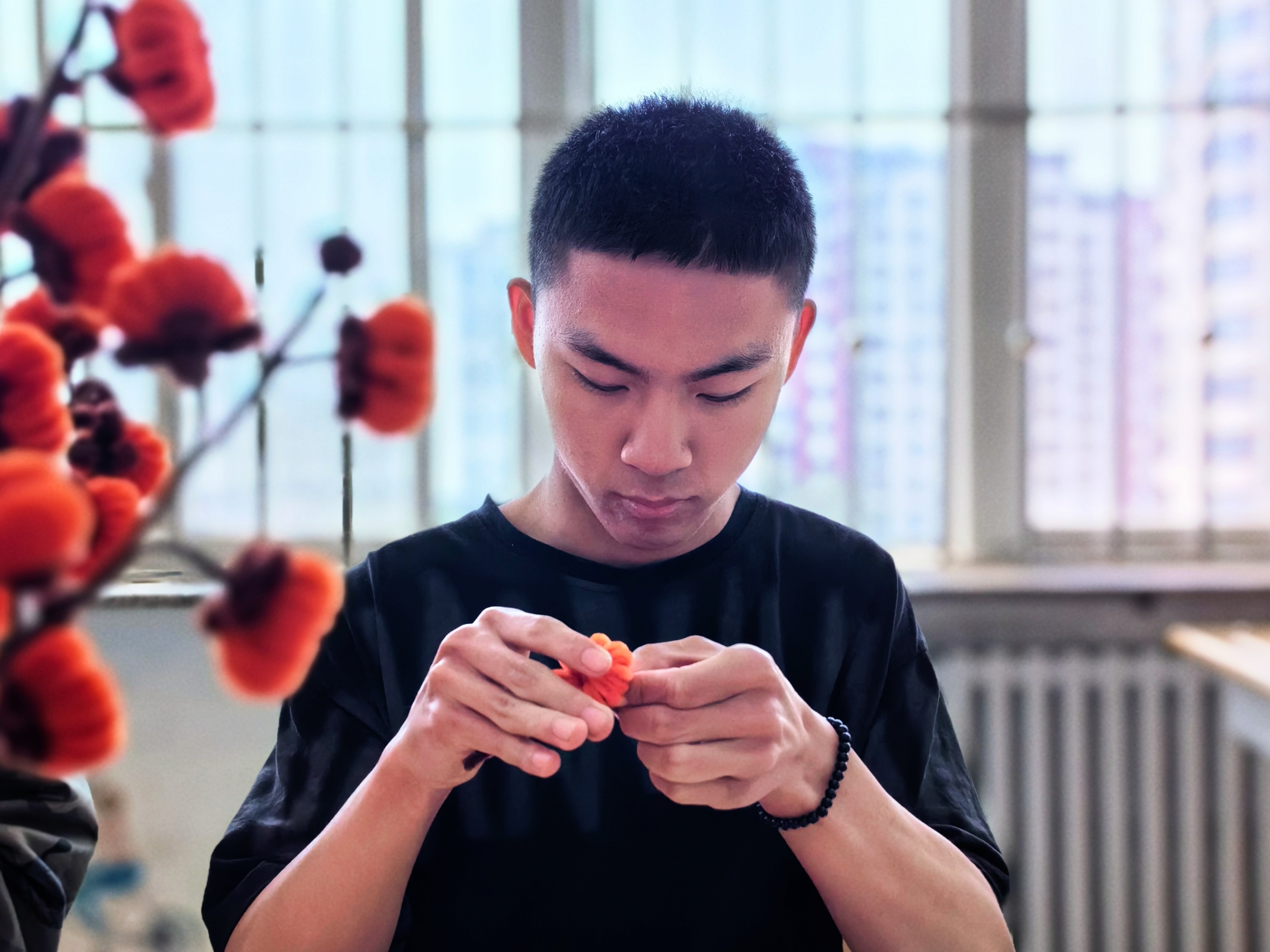 的另一角,高一学生肖凯正在快手社交平台直播扭扭棒手工花制作过程