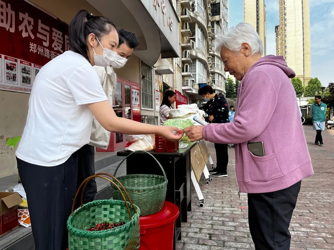 来自新安县仓头镇新仓村的驻村干部和村民代表摆摊销售土特产