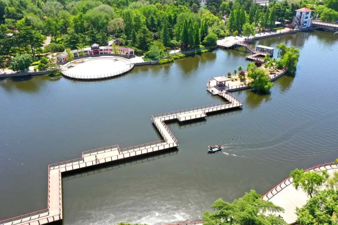 5月12日,山东省青岛市即墨区环卫中心的工人在墨水河打捞水上漂浮物.