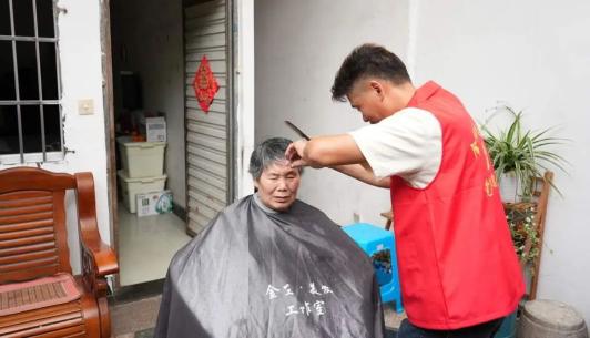 在金仙寺社区党群服务中心,社区工作人员和志愿者们早早准备好了理发