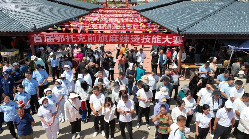 活动现场人头攒动,浓郁的麻辣烫香气便扑鼻而来,伴随着欢快的音乐,一