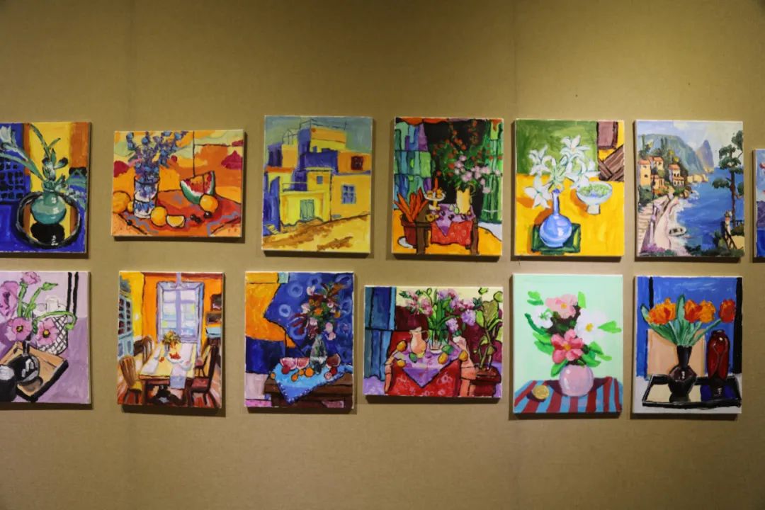 展览现场,一面墙上的22件油画作品色彩鲜艳,内容丰富,是小徐学习一年